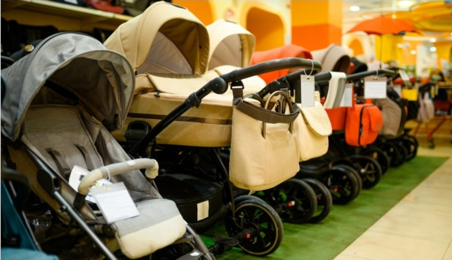 Flera barnvagnar uppställda på rad i en butik